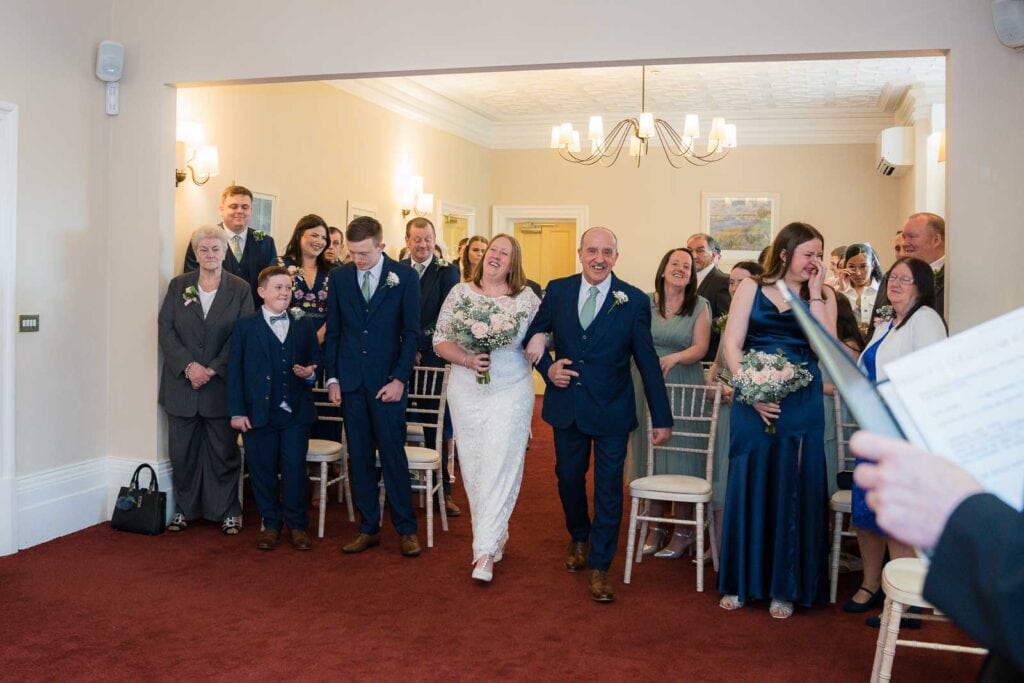 Bride walking down the aisle at Mansion House registry office wedding in Newport, captured by Newport wedding photographer Shutter Hire.