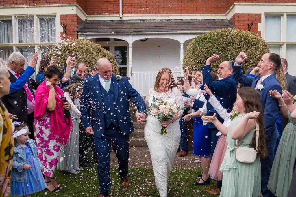 Candid confetti moment outside Mansion House registry office wedding venue in Newport photographed by South Wales wedding videographer.