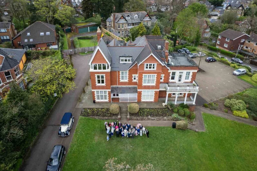 Drone wedding group outside Mansion House registry office wedding venue in Newport photographed by South Wales wedding videographer.